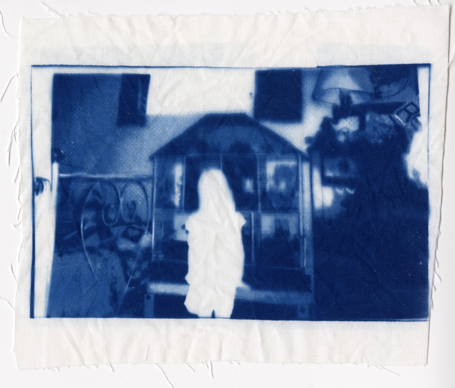 Blue cyanotype on frayed fabric of a childhood image of a blocked figure of a girl standing in front of a dollhouse